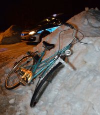 uszkodzony rower na poboczu drogi, w tle radiowóz