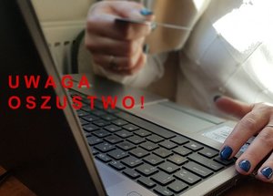 kobieta siedząca przy laptopie, w ręku trzyma kartę bankomatową