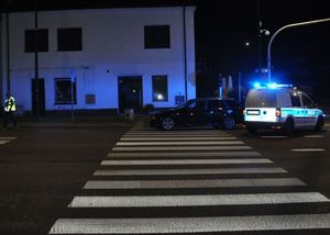 bmw stoi na przejściu dla pieszych, za nim radiowóz