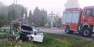 pojazd który uderzył w ogrodzenie, na drodze wóz bojowy straży pożarnej