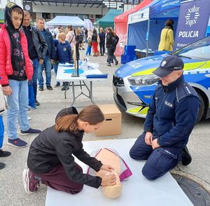 policjant podczas pikniku prezentuje jak przeprowadzać resuscytację