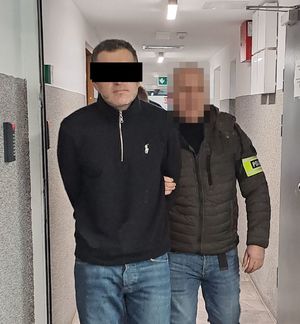 policjanci prowadzą zatrzymanego
