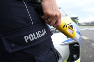 policjant trzyma urządzenie do badania stanu trzeźwości