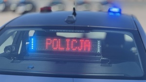 tył nieoznakowanego radiowozu i napis Policja