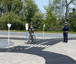 policjant i dziecko jadące na rowerze podczas konkursu