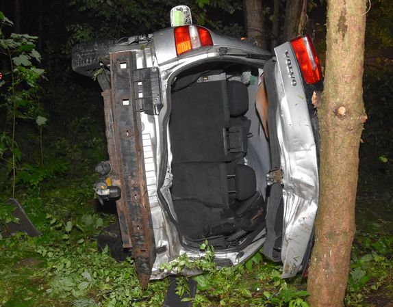 tył pojazdu leżącego na boku w lesie
