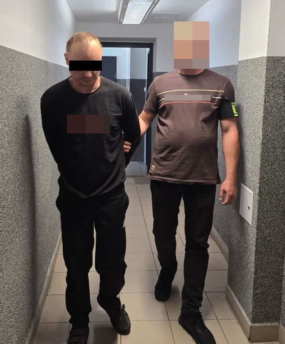policjant prowadzi zqatrzymanego