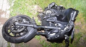 motocykl leży na boku w przydrożnym rowie