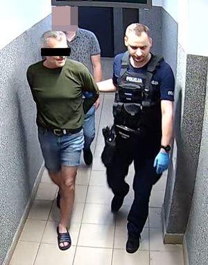 policjant prowadzi zatrzymanego