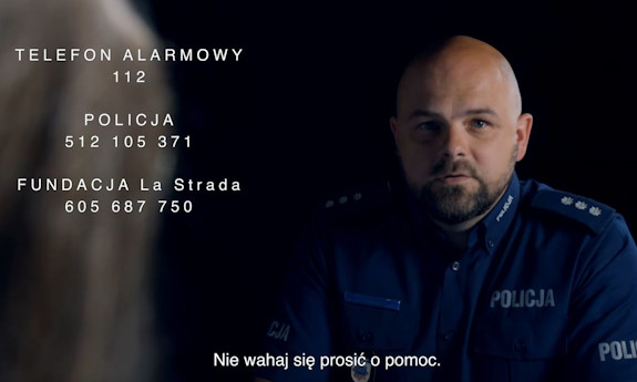 Z prawej strony umundurowany policjant, poniżej napis Nie wahaj się prosić o pomoc, z lewej strony napisy Telefon alarmowy 112, pod spodem napis Policja 512 105 371, Fundacja LaStrada 605 687750.
