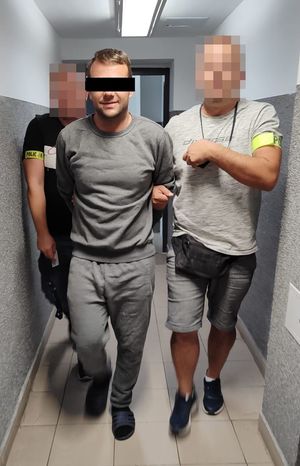 policjanci prowadzą zatrzymanego