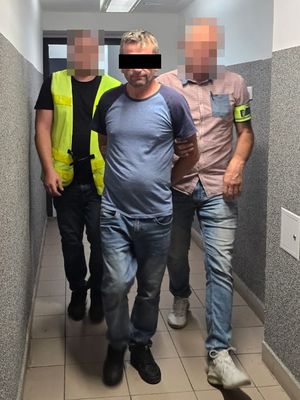 policjanci prowadzą zatrzymanego