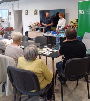 policjant oraz inne osoby podczas spotkania z seniorami
