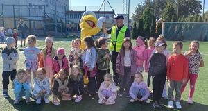 policjant i maskotka mrówki na wspólnym zdjęciu z dziećmi