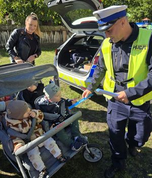 policjant daje dzieciom odblaski