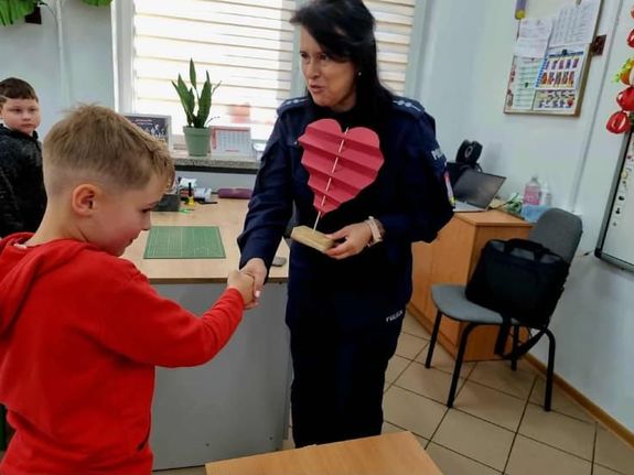 chłopiec wręcza policjantce papierowe serce