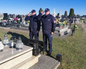 policjanci oddają honor przed pomnikiem zmarłego policjanta