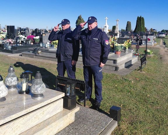 policjanci oddają honor przed pomnikiem zmarłego policjanta