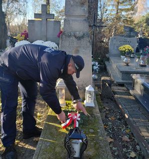 policjant kładzie wiązankę na grobie