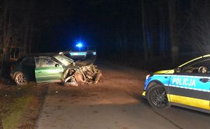 rozbity samochód na drodze, obok radiowozy