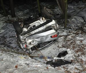 auto leżące na dachu po wypadku  na drodze ośnieżonej