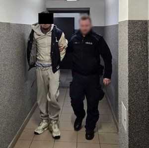 policjant prowadzi zatrzymanego mężczyznę