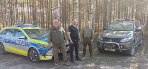 wspólne zdjęcie policjanta i strażników leśnych