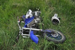 uszkodzony motocykl leży na trawie