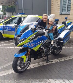 policjantka i mały chłopiec na motocyklu pozują do zdjecia