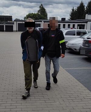 policjanci prowadzą zatrzymanego