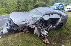 rozbity samochód na poboczu drogi, w tle radiowóz i samochód