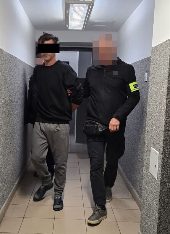 policjanci prowadzą zatrzymanego mężczyznę