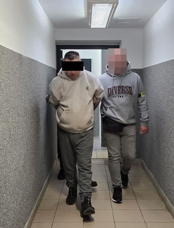 policjanci prowadzą zatrzymanego mężczyznę