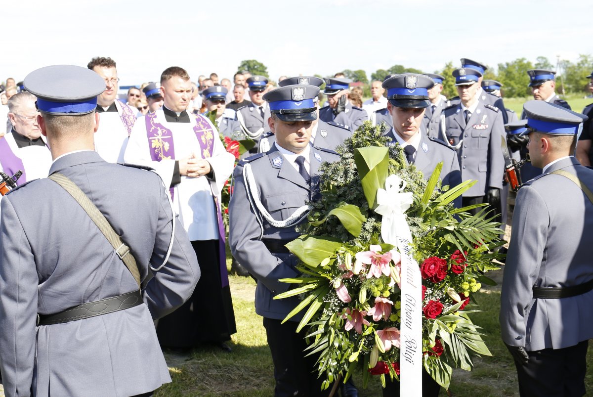 Policjanci kładą wieniec na grobie sierż. szt. Tomasza Iwańca.  