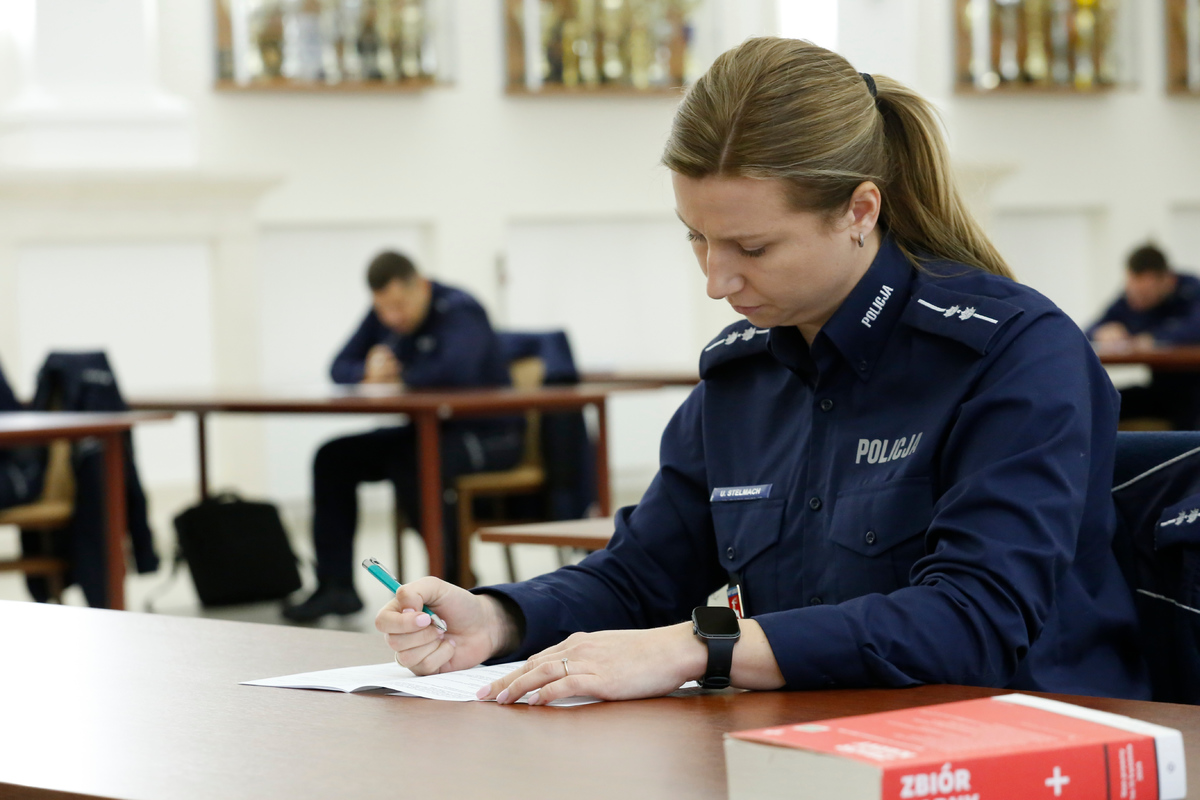 policjantka siedzi przy stole i rozwiązuje test