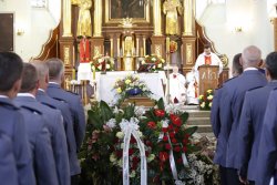 Wnętrze kościoła, w środku zdjęcia trumna z ciałem sierż. szt. Tomasza Iwańca otoczona wieńcami.