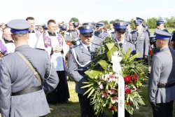 Policjanci kładą wieniec na grobie sierż. szt. Tomasza Iwańca.