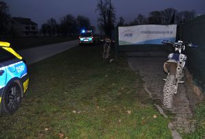 Dwa motocykle crossowe po wypadku i policyjne radiowozy